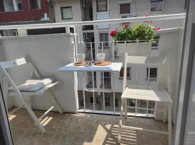 a balcony with a table and chairs on a balcony at Apartman Nicolas in Karaburma
