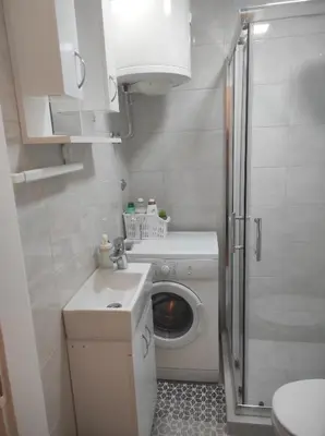 a small bathroom with a washing machine and a washer at Apartman Nicolas in Karaburma