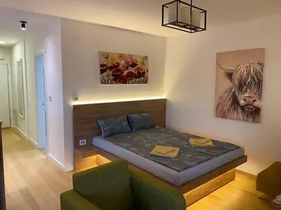 a bedroom with a bed with a cow on the wall at Vrtovi Ceraka in Belgrade