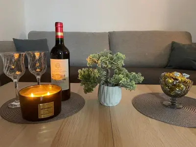 a bottle of wine and two glasses on a table at Apartman Una in Batajnica