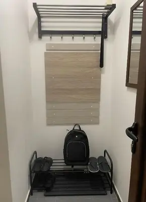 a black backpack sitting on a bench in a room at Apartman Una in Batajnica