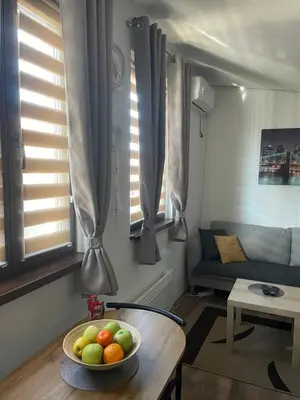 a living room with a bowl of fruit on a table at Apartman Una in Batajnica