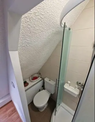 a small bathroom with a toilet and a glass door at Srce Beograda in Belgrade