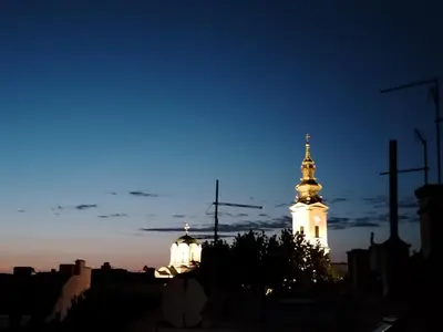 a lit up building with a steeple at night at Srce Beograda in Belgrade