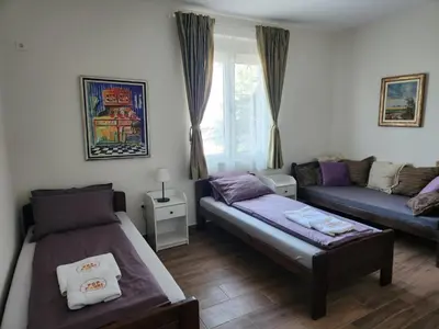 a living room with two beds and a couch at RoomsApartments PopCOURT Tenis Centar in Pančevo