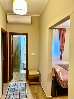 a bedroom with a bed and a bathroom with a shower at RoomsApartments PopCOURT Tenis Centar in Pančevo