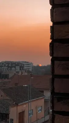 a view of a city at sunset from a building at Apartman Arija in Ruma