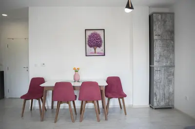 a dining room with a table and four chairs at Apartman Arija in Ruma