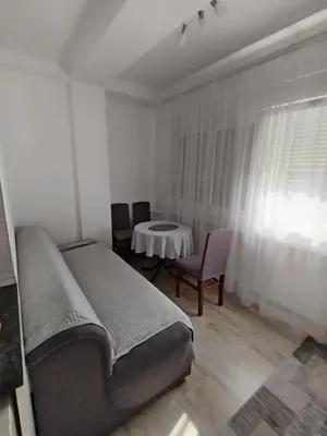 a bedroom with a bed and a table and chairs at Meli apartman in Smederevo