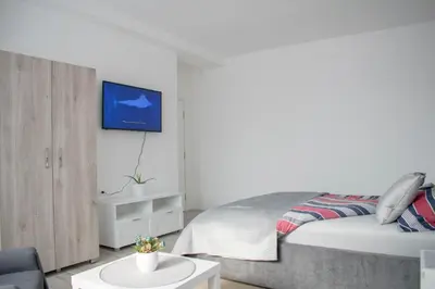 a bedroom with a bed and a tv on a wall at Meli apartman in Smederevo