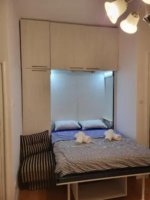a bed with two pillows and a chair in a room at Kod Vuka in Belgrade