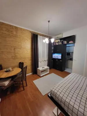 a bedroom with a table and a bed and a dining room at Kod Vuka in Belgrade