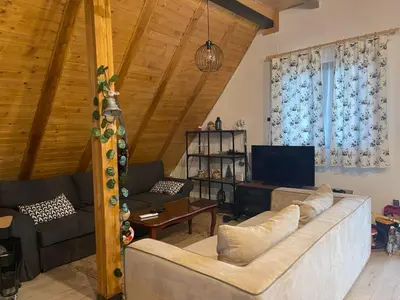 a living room with a couch and a tv at Vikendica sa bazenom u blizini Beograda in Veliki Borak