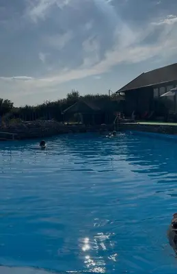 a pool of blue water with people swimming in it at Vikendica sa bazenom u blizini Beograda in Veliki Borak