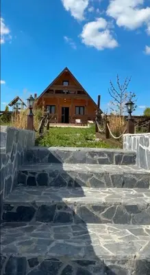 a house with stone steps in front of a house at Vikendica sa bazenom u blizini Beograda in Veliki Borak