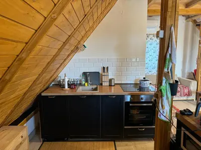 a kitchen with black cabinets and a wooden counter top at Vikendica sa bazenom u blizini Beograda in Veliki Borak
