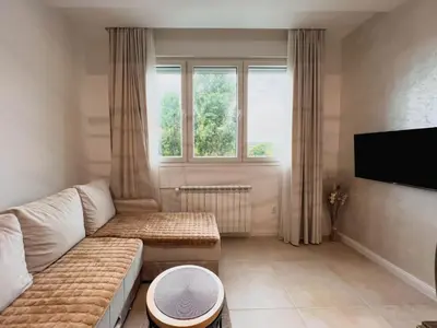 a living room with a couch and a large window at Fantasy Apartment in Belgrade