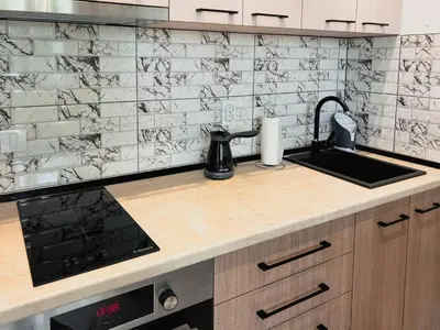 a kitchen with a black and white tiled wall at Fantasy Apartment in Belgrade