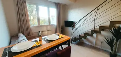 a living room with a table and a staircase at Fantasy Apartment in Belgrade