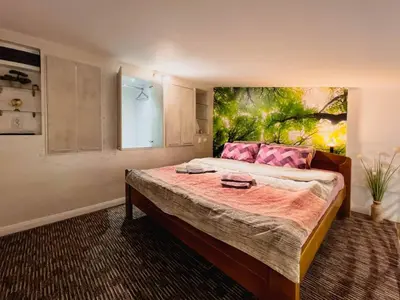 a bedroom with a large bed with a painting on the wall at Fantasy Apartment in Belgrade