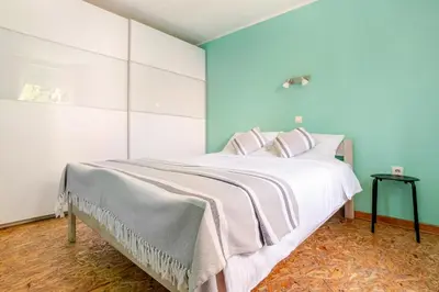 a bedroom with a large white bed with pink pillows at White Bear 1663 Zemun Oldest House Apartment in Zemun