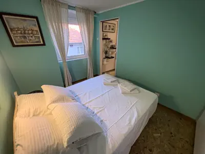 a bedroom with a white bed with a window at White Bear 1663 Zemun Oldest House Apartment in Zemun