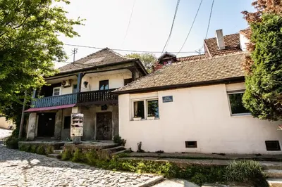 an old house with a balcony on a street at White Bear 1663 Zemun Oldest House Apartment in Zemun