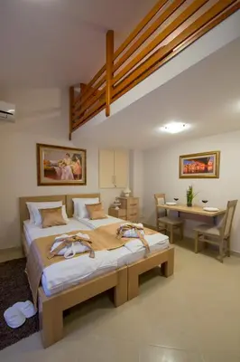a bedroom with a bed and a desk and a table at Apartments Jevtic in Belgrade