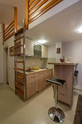 a kitchen with a bar stool in the middle of a room at Apartments Jevtic in Belgrade