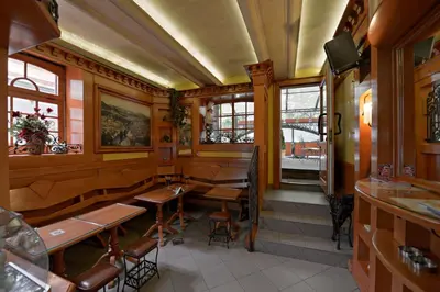 a restaurant with wooden walls and tables and windows at Apartments Jevtic in Belgrade