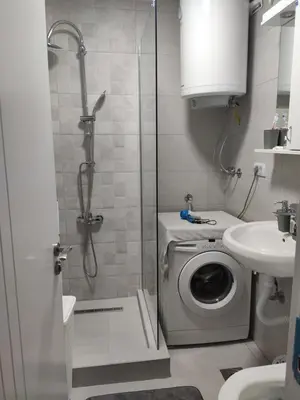 a bathroom with a shower and a washing machine at KS Studio in Borča