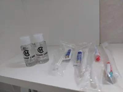 a bathroom counter with toothbrushes and a bottle of water at KS Studio in Borča