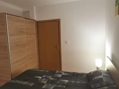 a bedroom with a bed and a wooden closet at LoLa5 in Novi Grad
