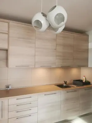 a kitchen with white cabinets and a sink and lights at LoLa5 in Novi Grad