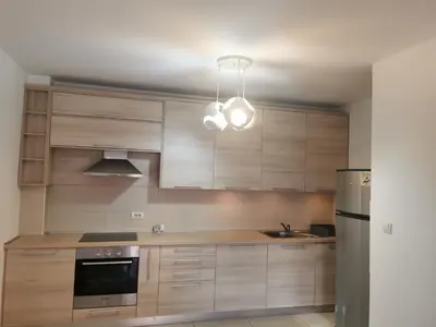 a kitchen with wooden cabinets and a light fixture at LoLa5 in Novi Grad