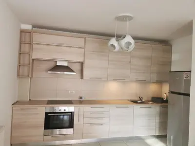 a kitchen with wooden cabinets and a stainless steel refrigerator at LoLa5 in Novi Grad