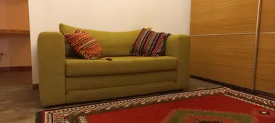 a green chair with two pillows on it in a room at Botanic Garden 1 in Belgrade
