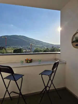 two chairs sitting at a bar in front of a window at Iris apartman in Arandjelovac