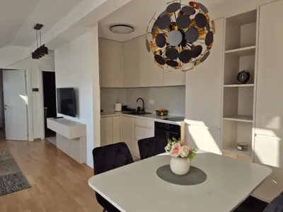 a kitchen and dining room with a table and chairs at Iris apartman in Arandjelovac