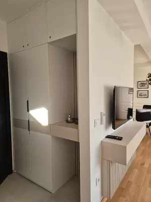a living room with white cabinets and a desk at Iris apartman in Arandjelovac