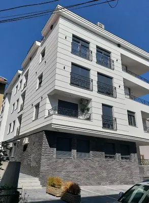 a white building with balconies on the side of it at Iris apartman in Arandjelovac