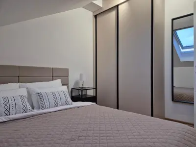 a bedroom with a large bed with white pillows at Iris apartman in Arandjelovac