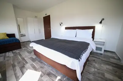 a bedroom with a large bed and a blue couch at Guesthouse & restaurant Tekovina in Smederevo