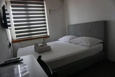a bedroom with a bed with a teddy bear on it at Guesthouse & restaurant Tekovina in Smederevo