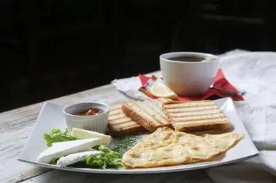 a plate of food with toast and a cup of coffee at Guesthouse & restaurant Tekovina in Smederevo