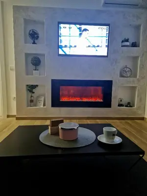 a living room with a fireplace with a tv above it at lux two in Nova Pazova