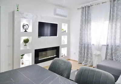 a living room with a table and a fireplace at lux two in Nova Pazova