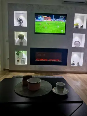 a living room with a tv above a fireplace at lux two in Nova Pazova