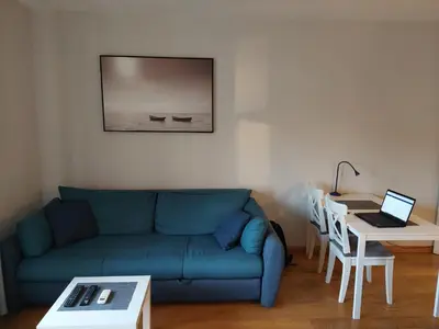 a living room with a couch and a table with a laptop at Apartment Premier 1 A Blok in Belgrade