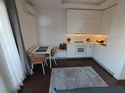 a small white kitchen with a table and chairs at Apartment Premier 2 A Blok in Belgrade